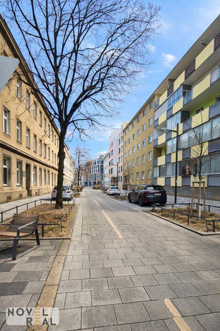 Ruhige Wohnstraße mit Bäumen und gepflegten Gehwegen in einem städtischen Viertel.