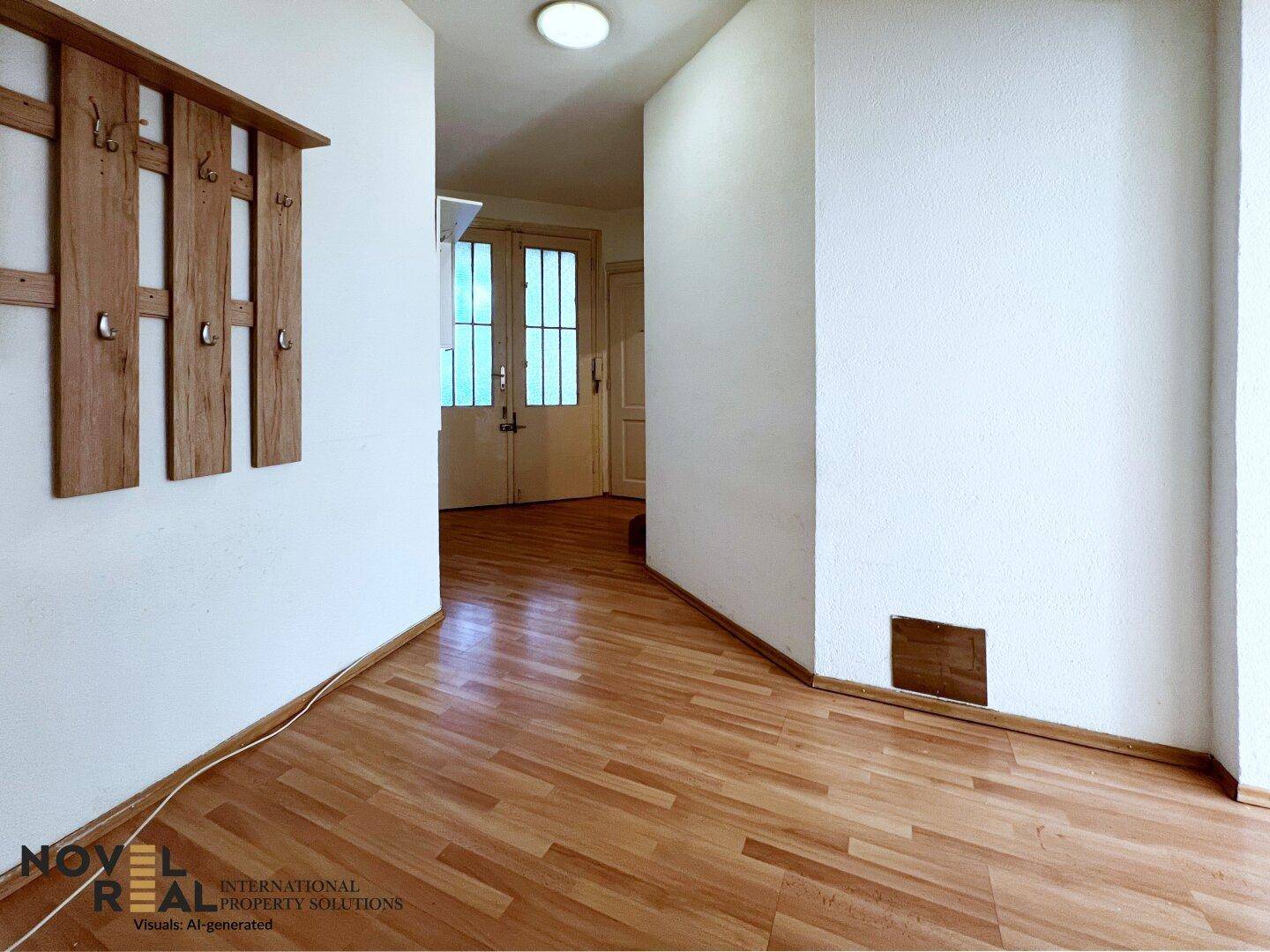 Heller Flur mit Holzparkettboden, Garderobe und Blick auf eine Doppeltür.