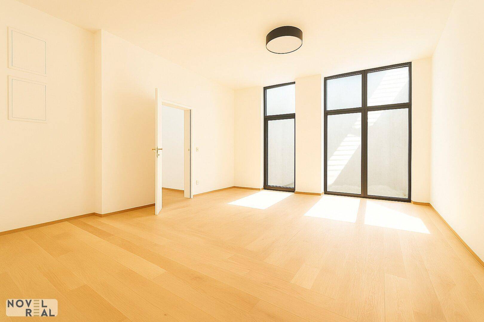 Geräumiges Schlafzimmer mit Holzboden, großen Fenstern und viel natürlichem Licht für eine angenehme Atmosphäre.