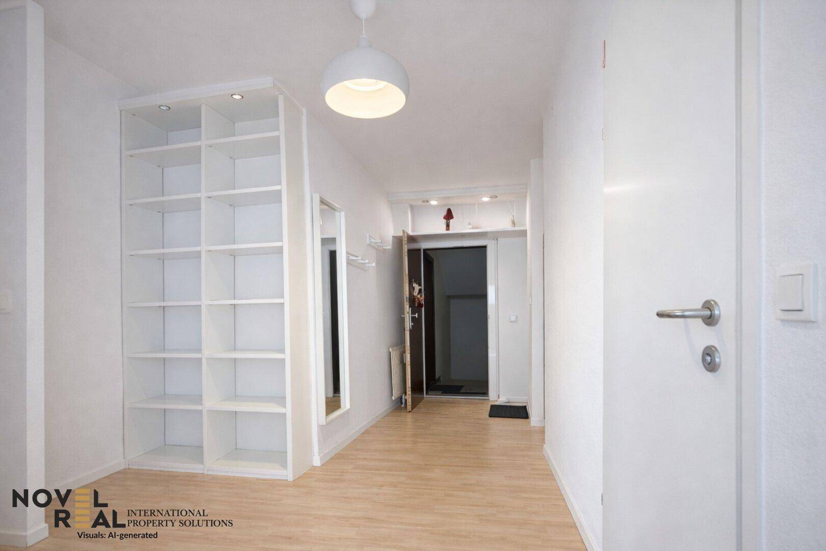 Heller Flur mit Holzboden, Einbauregal und Garderobe am Eingangsbereich.