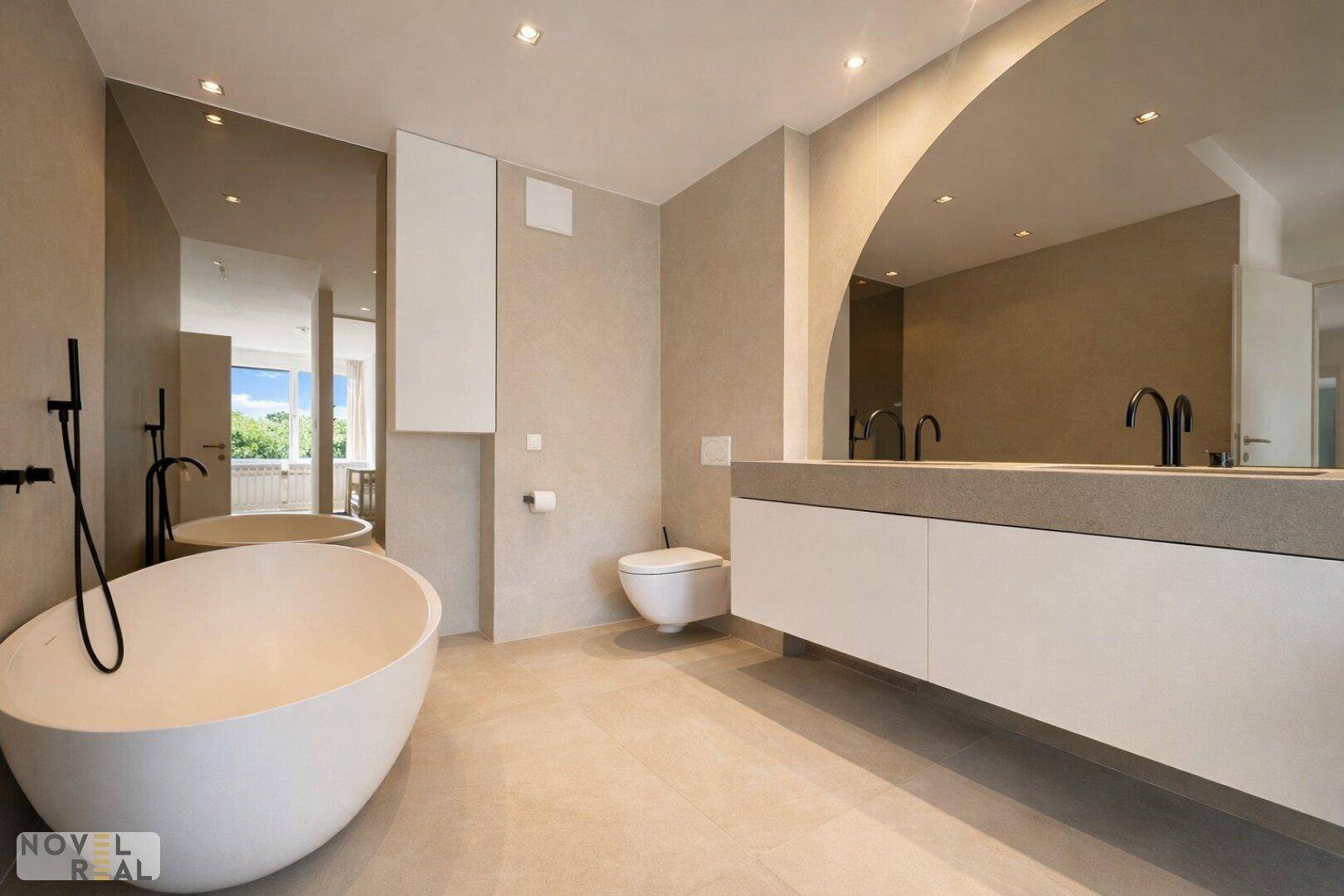 Luxuriöses Badezimmer mit freistehender Badewanne, Doppelwaschbecken und modernen Armaturen.