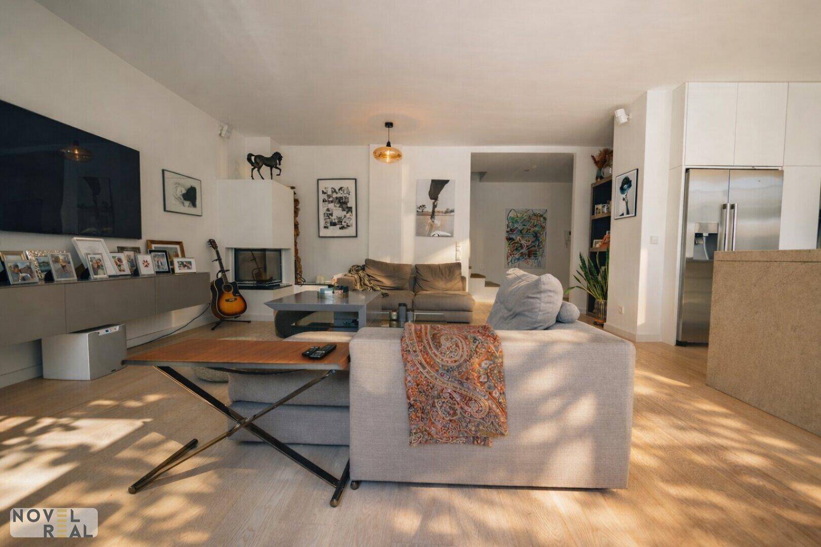 Helles Wohnzimmer mit modernem Kamin, Parkettboden und bequemen Sofas.