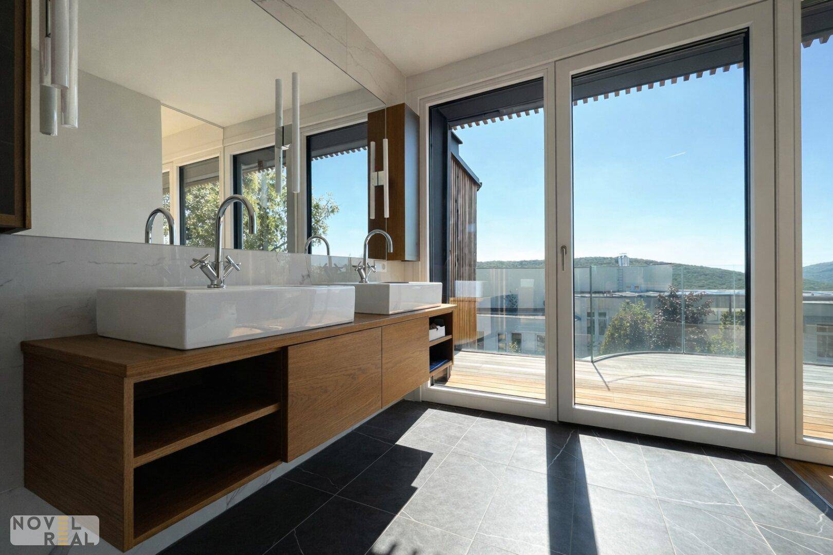 Elegantes Badezimmer mit Doppelwaschbecken, großen Fenstern und direktem Zugang zur Terrasse.
