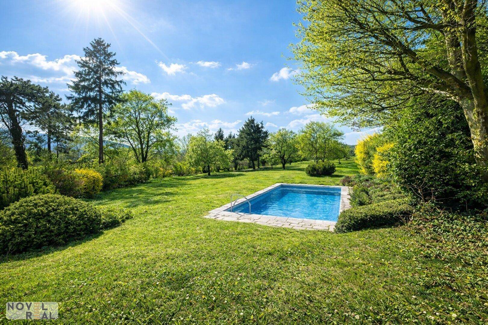 Idyllischer Gartenbereich mit kleinem Pool, umgeben von üppigem Grün und Bäumen.