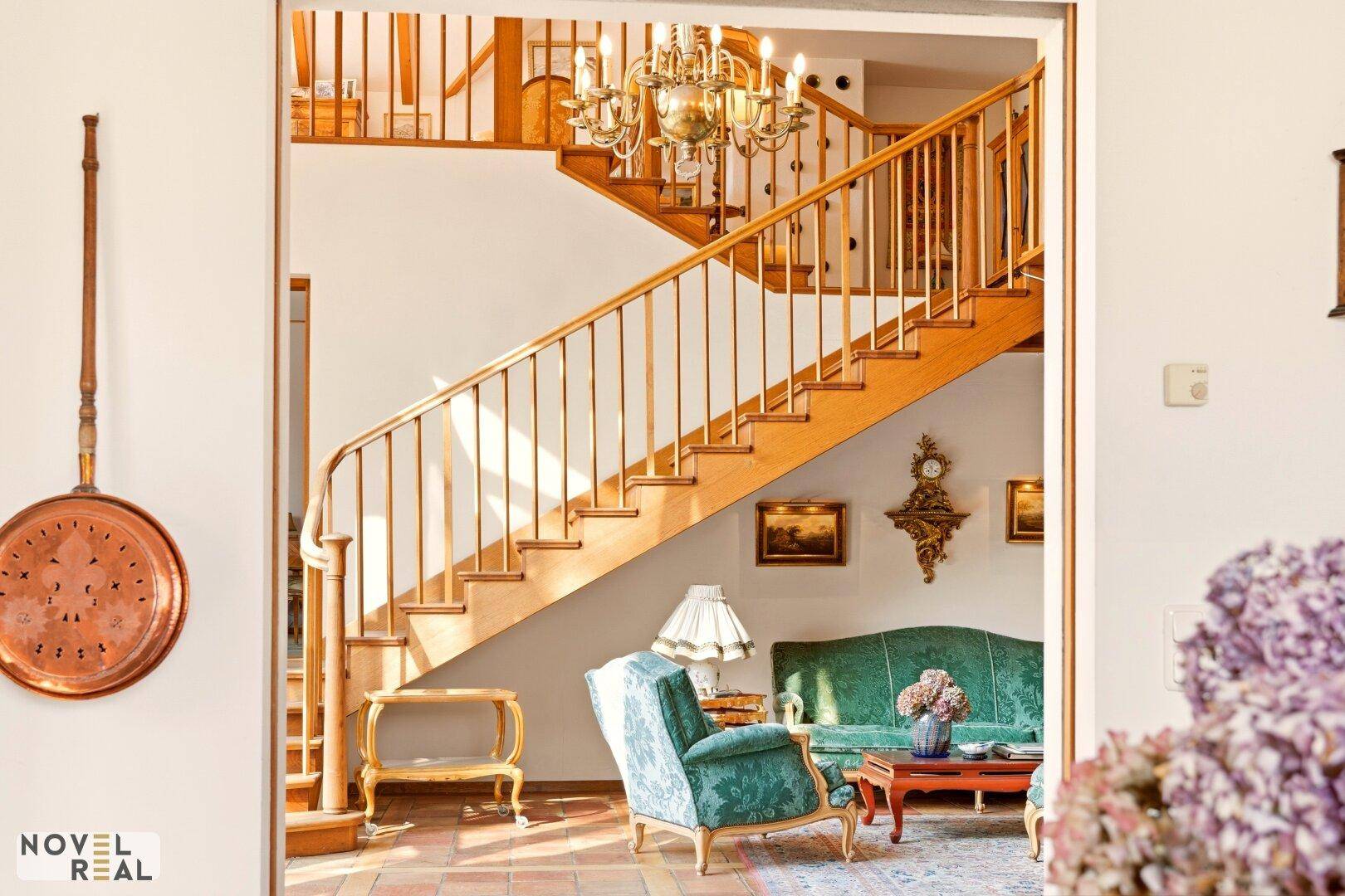 Gemütlicher Wohnbereich mit eleganter Einrichtung und Zugang zur Holztreppe.