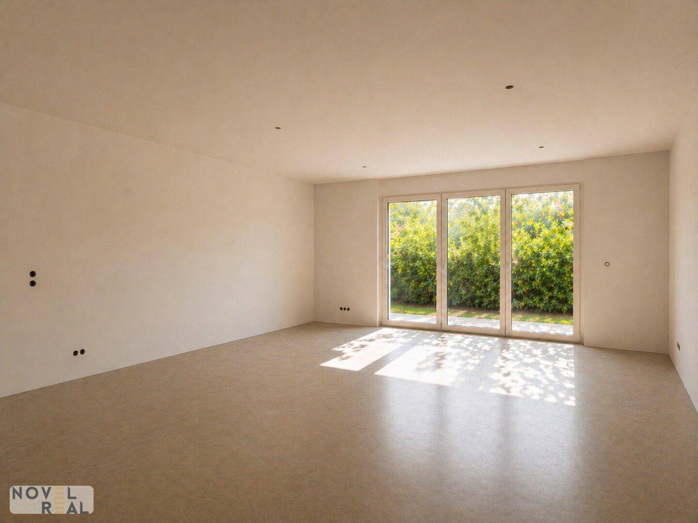 Heller, leerer Raum mit großen Fenstern und Blick ins Grüne, ideal für Wohnzimmer.