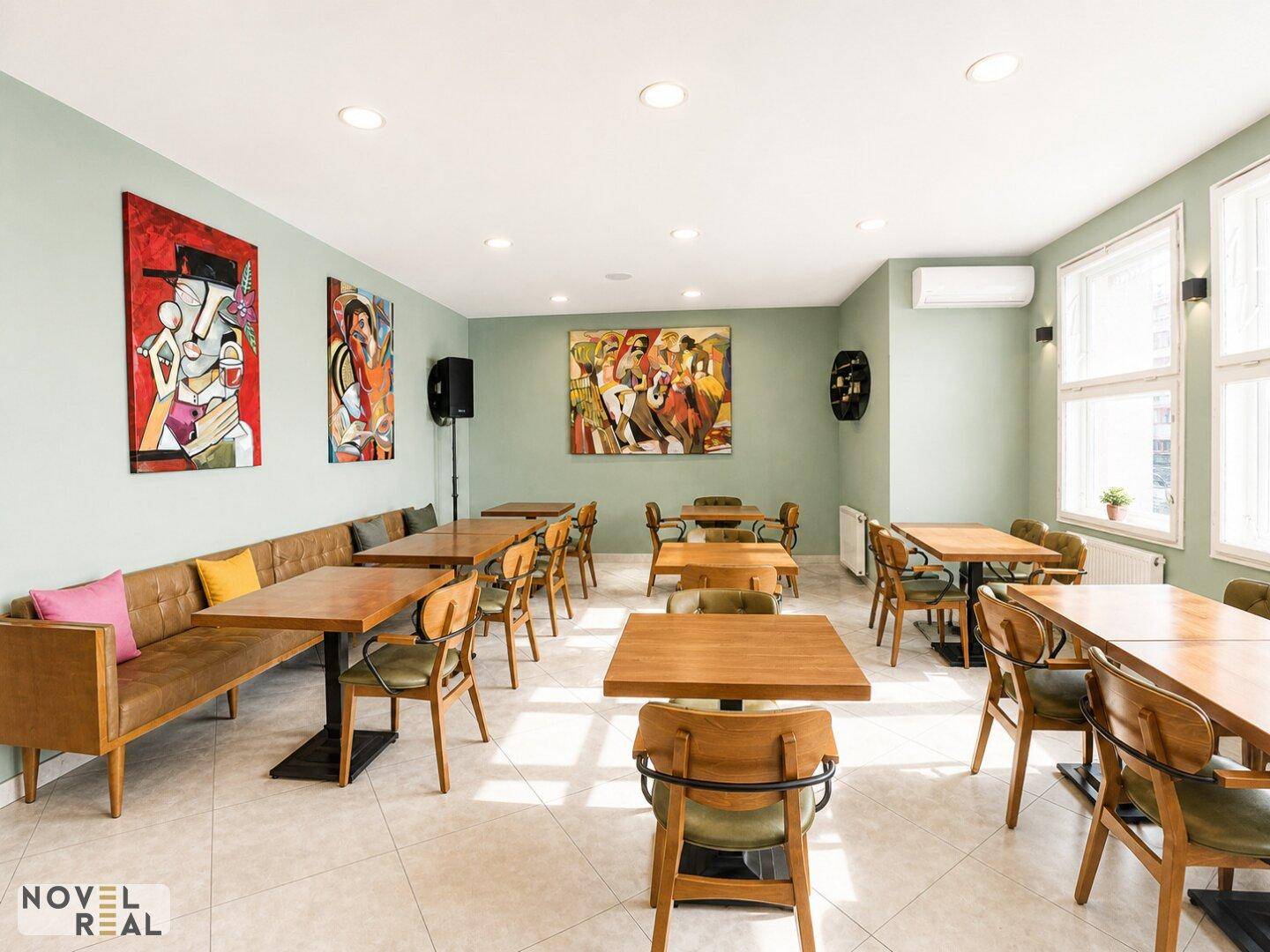 Geräumiger Restaurantbereich mit vielen Sitzgelegenheiten, großen Fenstern und Klimaanlage für angenehmes Ambiente.