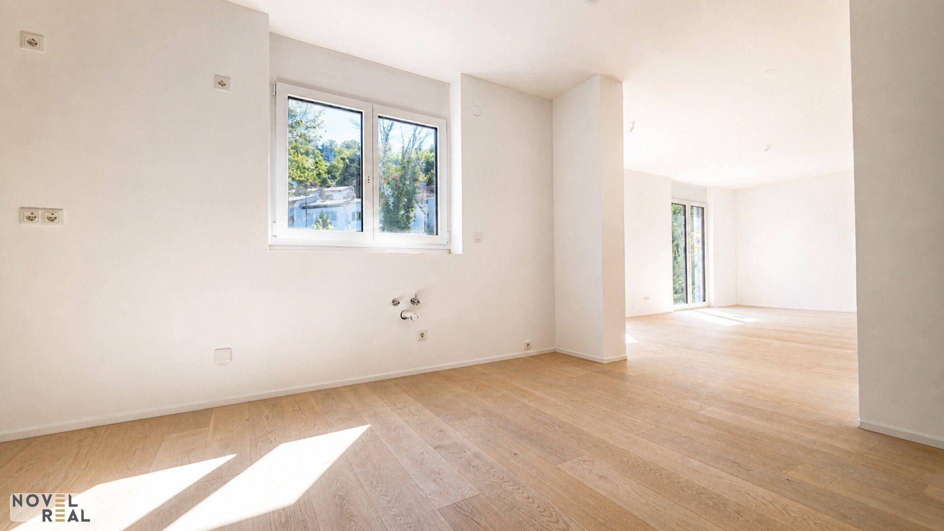 Heller Raum, vorbereitet für eine Küche, mit Fenster und Holzboden.
