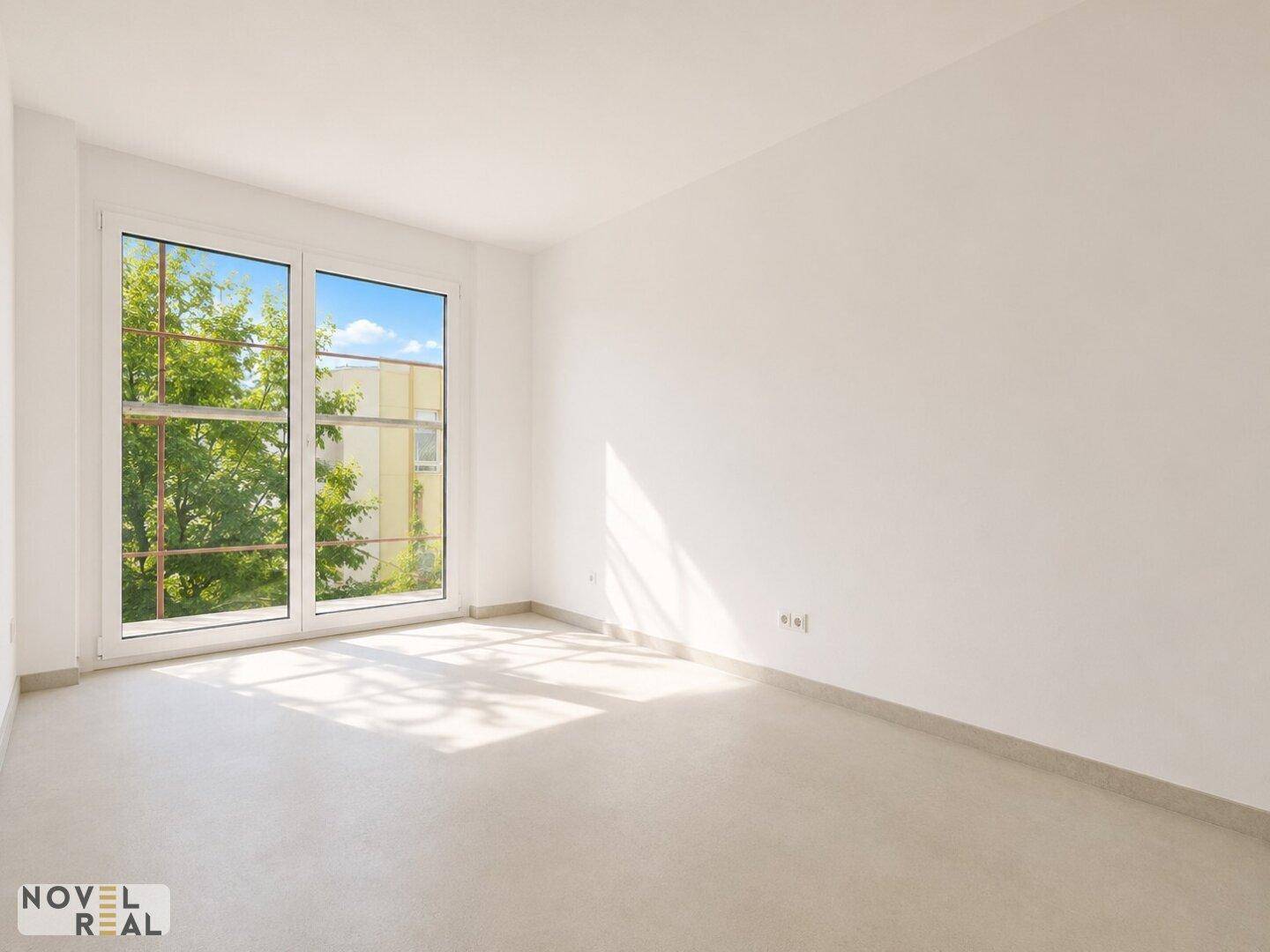 Heller Raum mit großem Fenster und Blick auf Bäume, geeignet als Schlaf- oder Arbeitszimmer in einem Neubau.