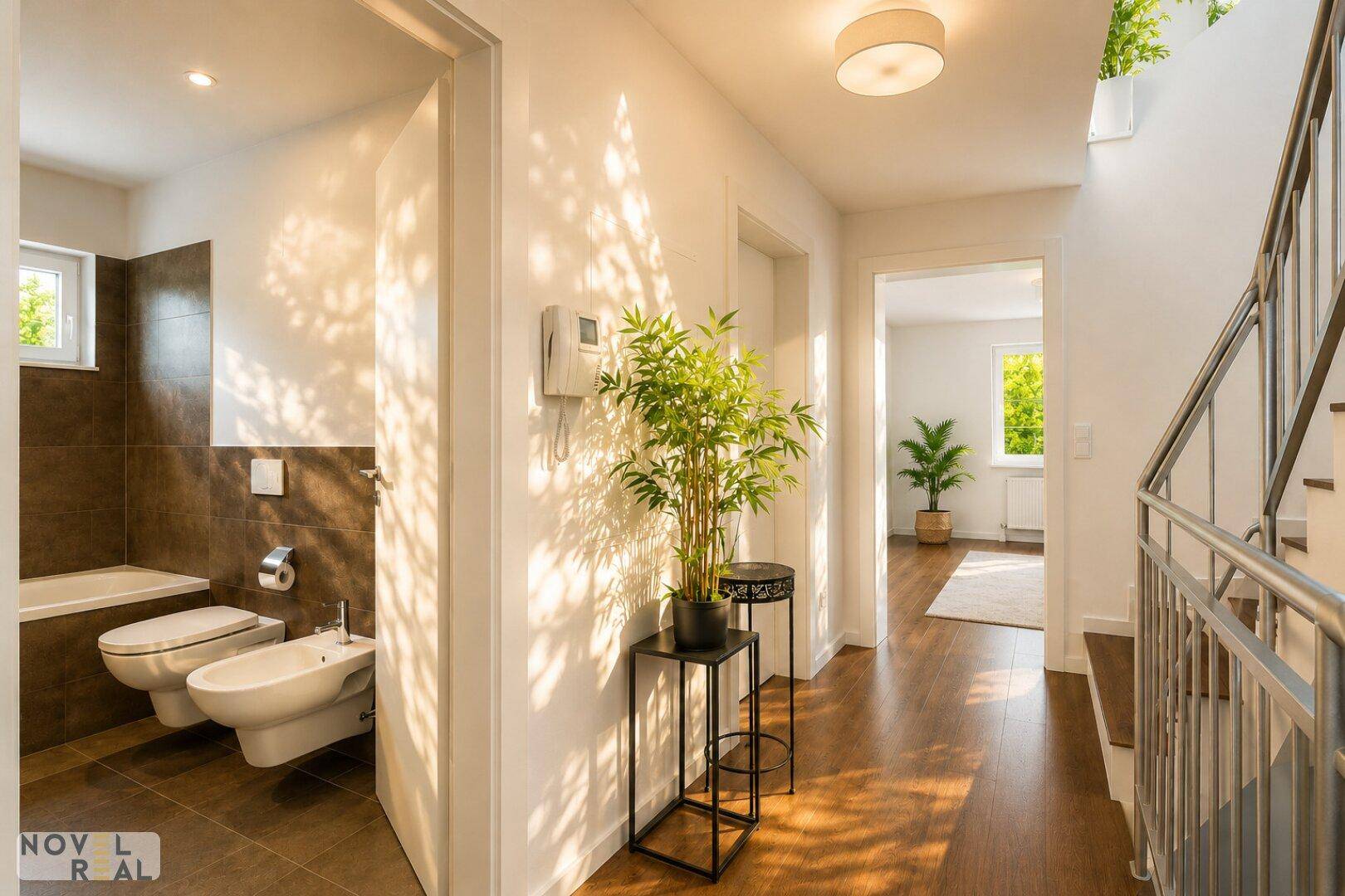 Heller Flur mit Holzboden und Blick in ein modernes Badezimmer mit Badewanne und Bidet.