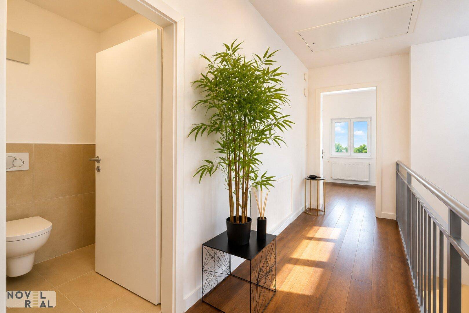Heller Flur mit Holzboden und Zugang zu einem separaten Gäste-WC.