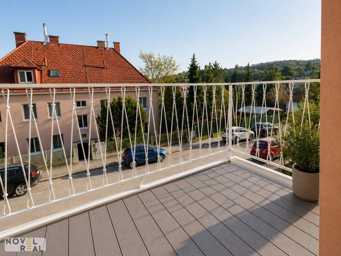 Geräumiger Balkon mit modernem Bodenbelag und Blick auf die umliegende Nachbarschaft.