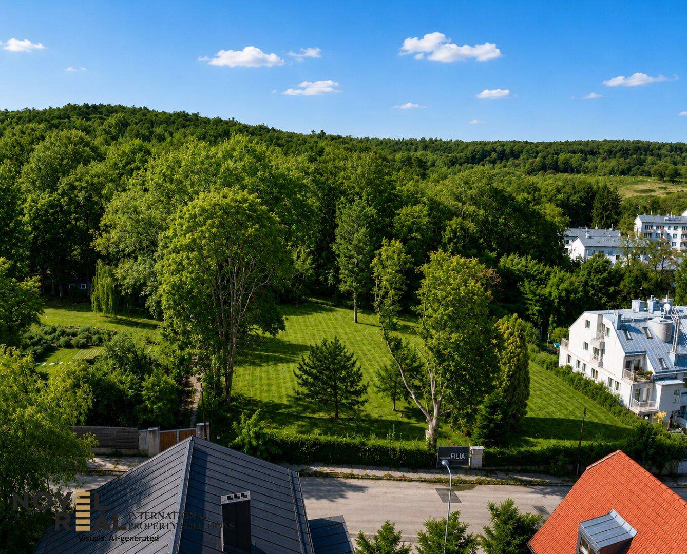 Luftaufnahme von Wohnhäusern am Waldrand mit üppiger grüner Vegetation unter blauem Himmel.