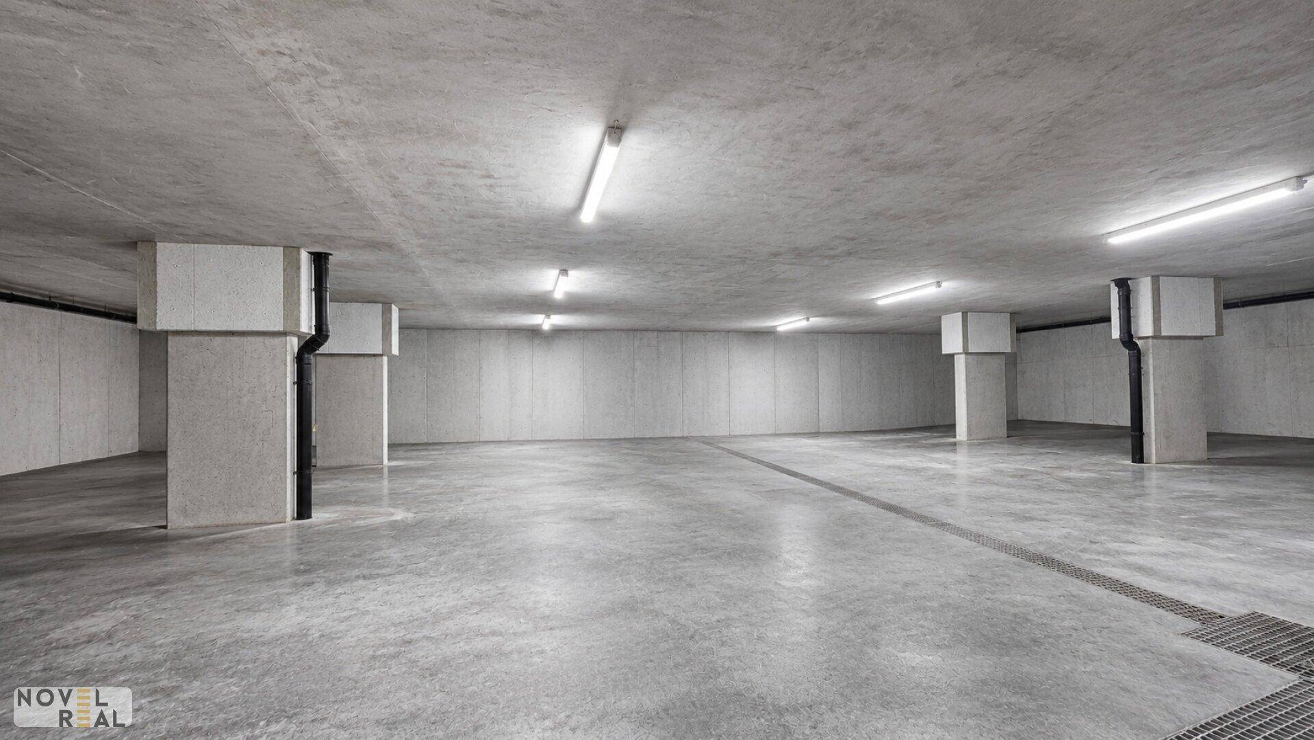 Geräumige Tiefgarage mit Betonboden und -säulen, bereit für die Nutzung durch Bewohner.