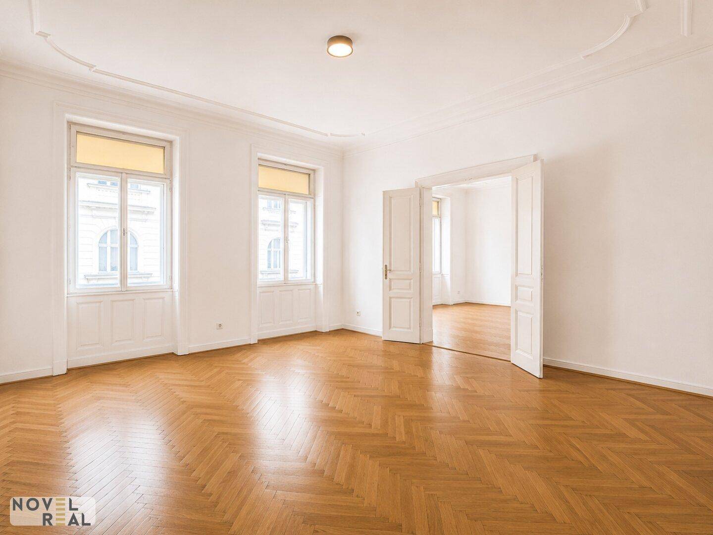 Helles Zimmer mit Fischgrätparkett und hohen Decken, bereit zur individuellen Gestaltung.