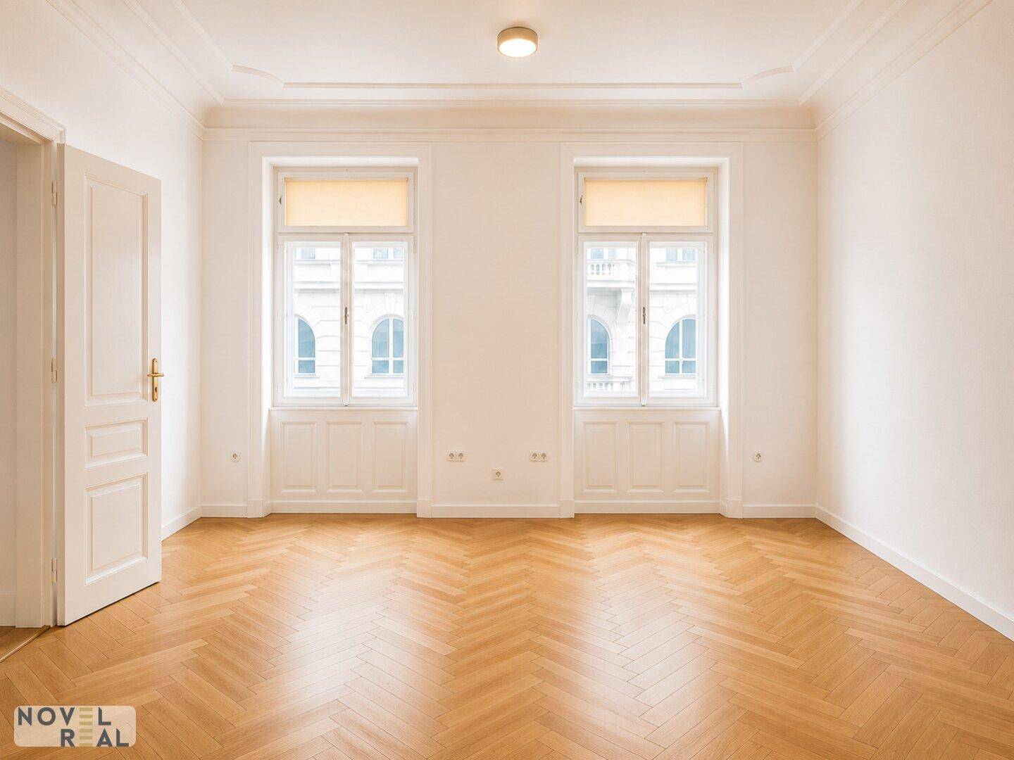Geräumiges Zimmer mit Laminatboden und großen Fenstern, bietet viel Tageslicht.