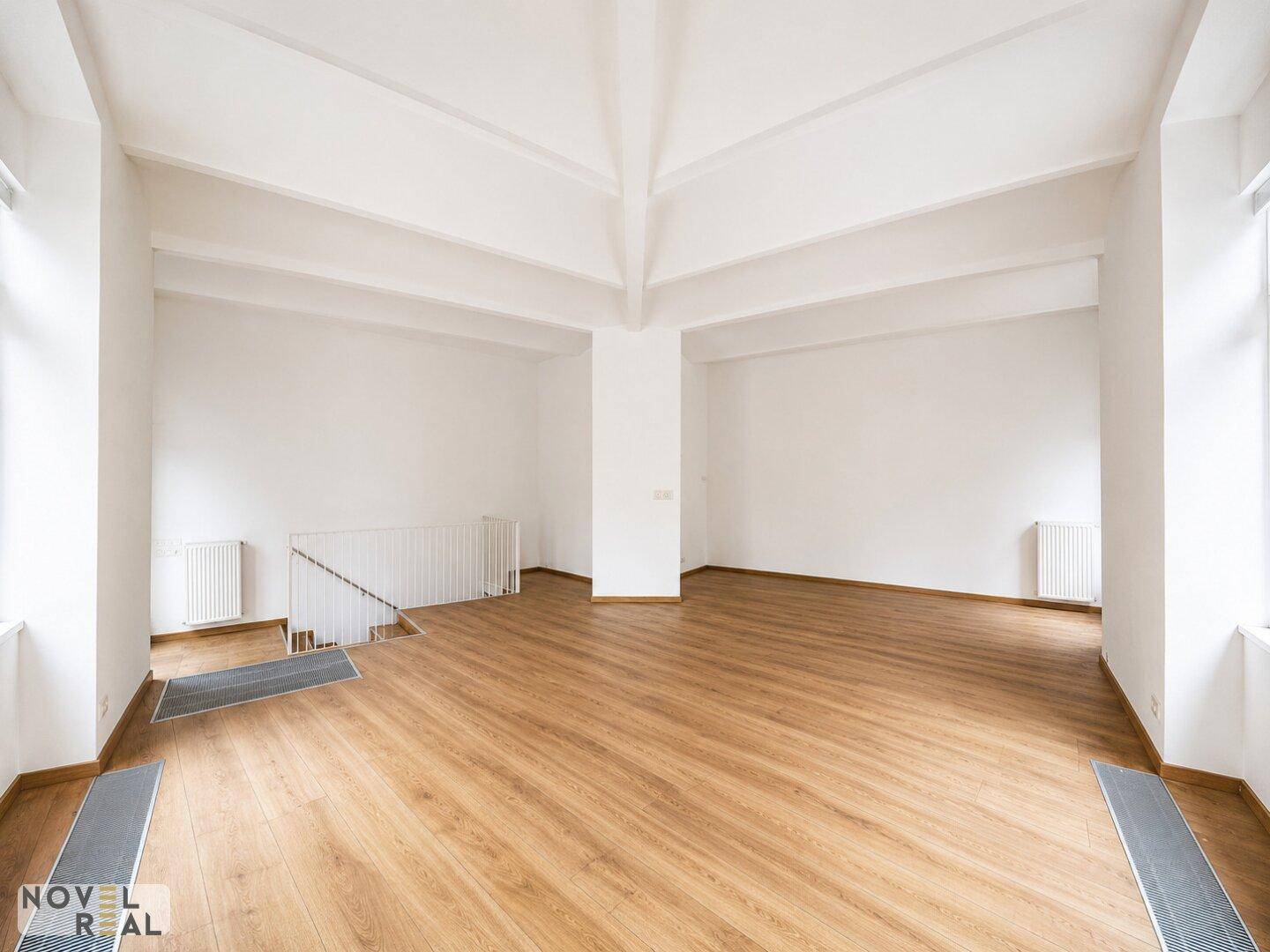 Großer, heller Raum mit Laminatboden und hohen Decken, ideal für offene Gestaltung.