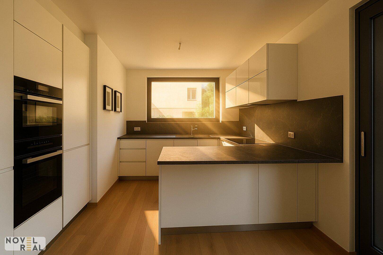 Moderne Küche mit weißen Schränken, dunklen Arbeitsplatten und eingebauten Geräten, hell beleuchtet durch ein Fenster.