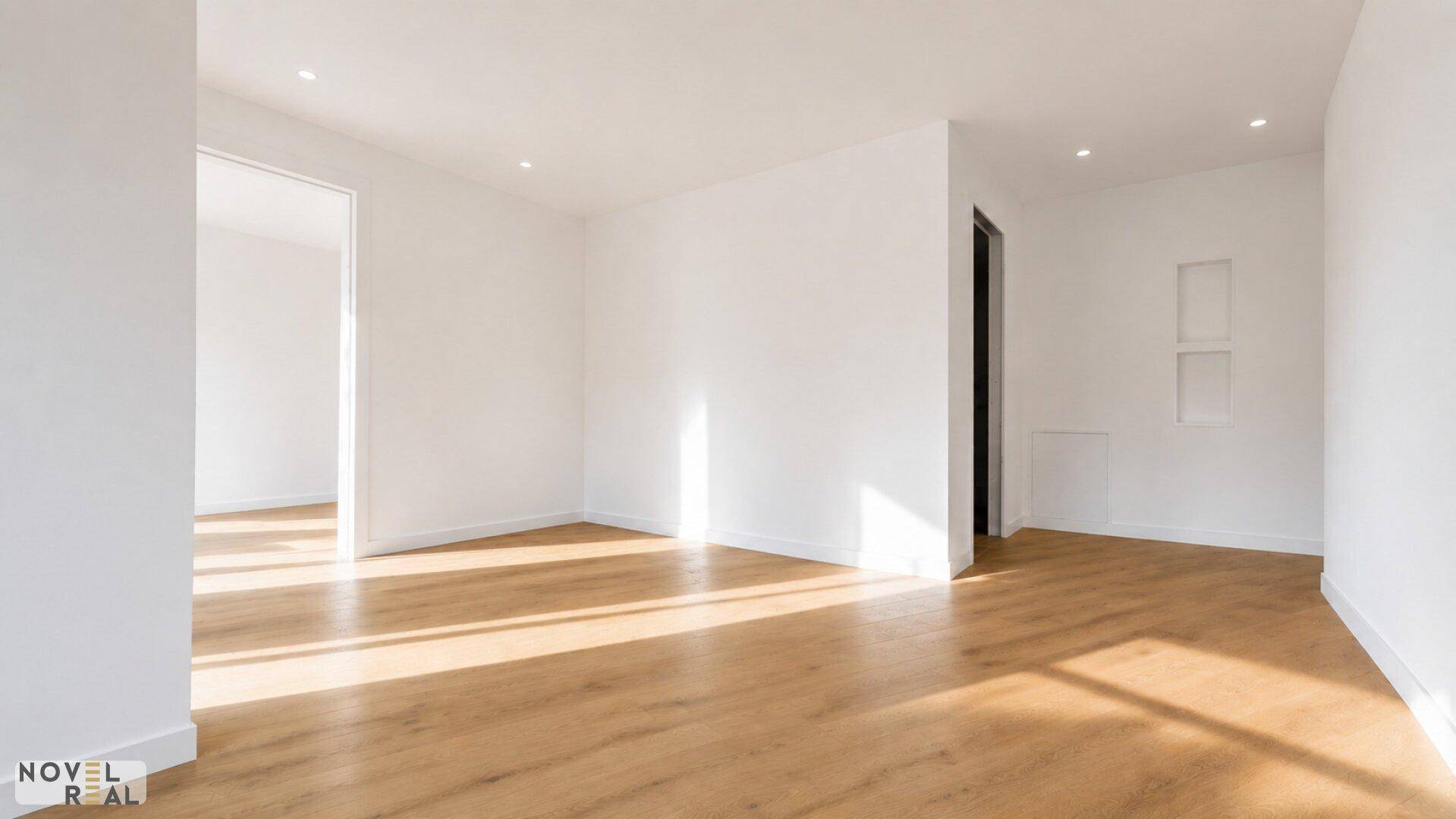 Heller, leerer Raum mit Holzboden und weißen Wänden, bereit für die Einrichtung.