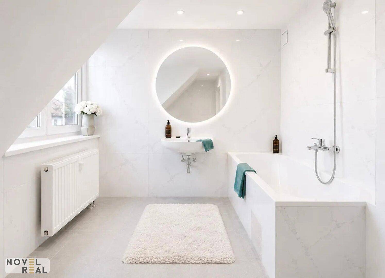 Modernes Badezimmer mit Badewanne, beleuchtetem Spiegel und Fenster in der Dachschräge.