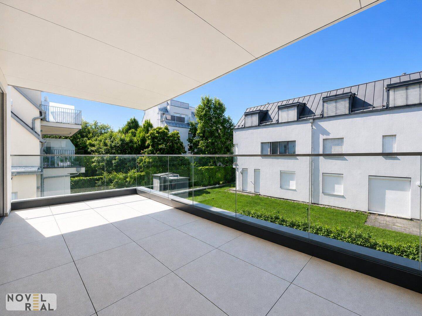 Großer Balkon mit Fliesenboden und Glasbrüstung, ideal für entspannte Stunden im Freien.