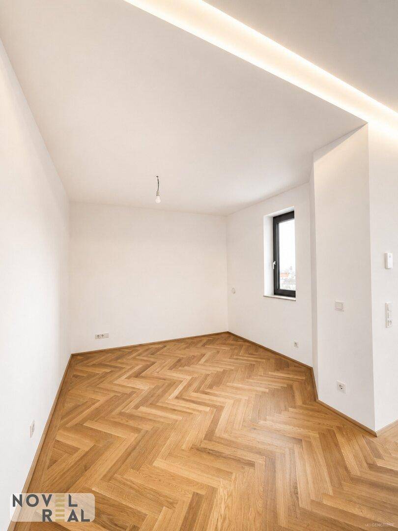 Helles Schlafzimmer mit Fischgrätparkett, weiß gestrichenen Wänden und indirekter Beleuchtung.
