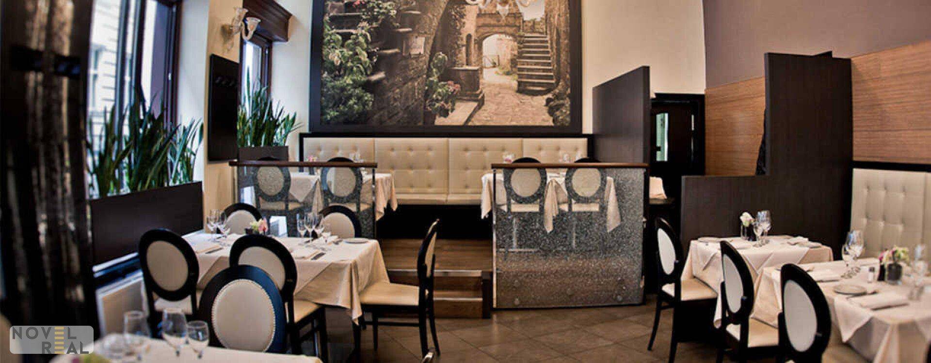 Einladender Restaurant-Speisesaal mit mehreren Tischen, bequemen Sitzbänken und einer großen Wandmalerei.