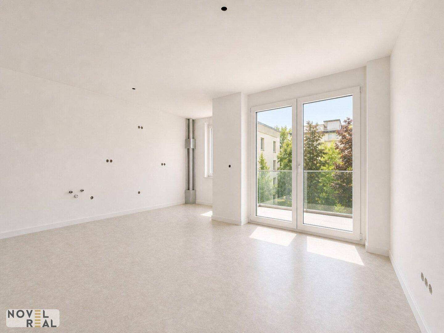 Leeres Zimmer mit hellem Boden, großen Fenstern und vorbereiteten Anschlüssen für eine Küche.
