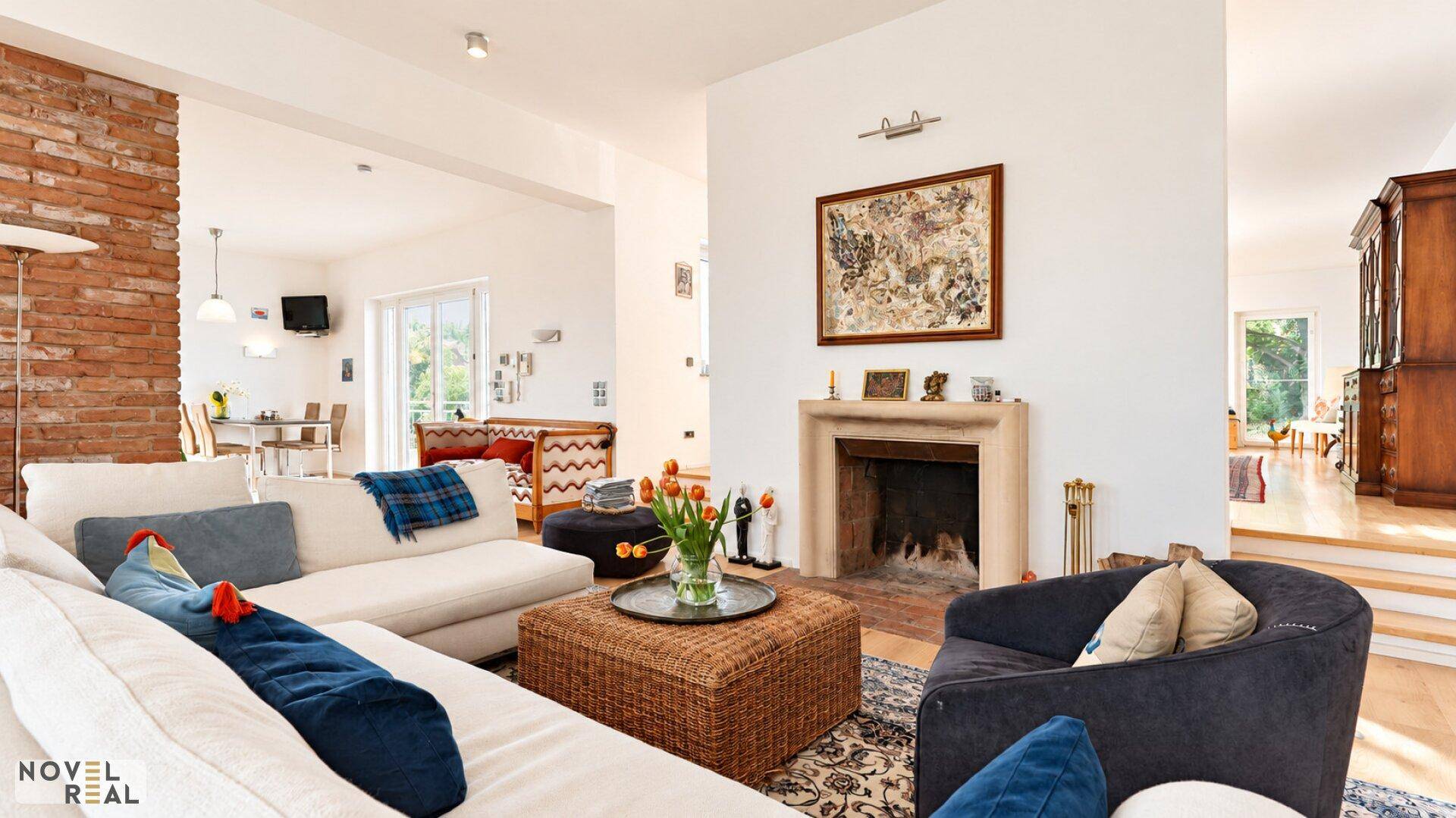 Gemütliches Wohnzimmer mit Kamin, bequemen Sofas und einer dekorativen Ziegelwand.