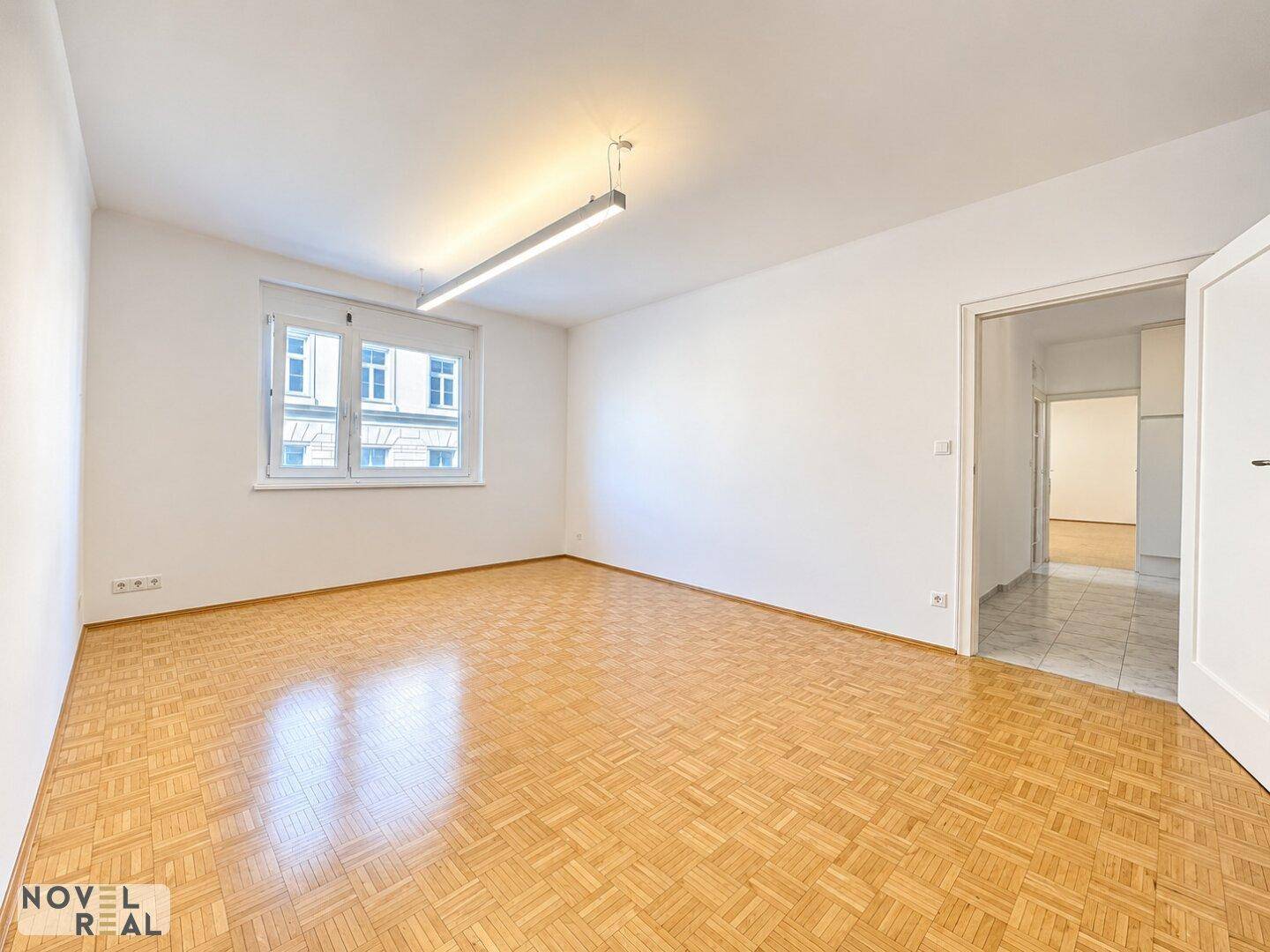 Heller Raum mit Mosaikparkettboden und Fenster, bereit zur individuellen Gestaltung.