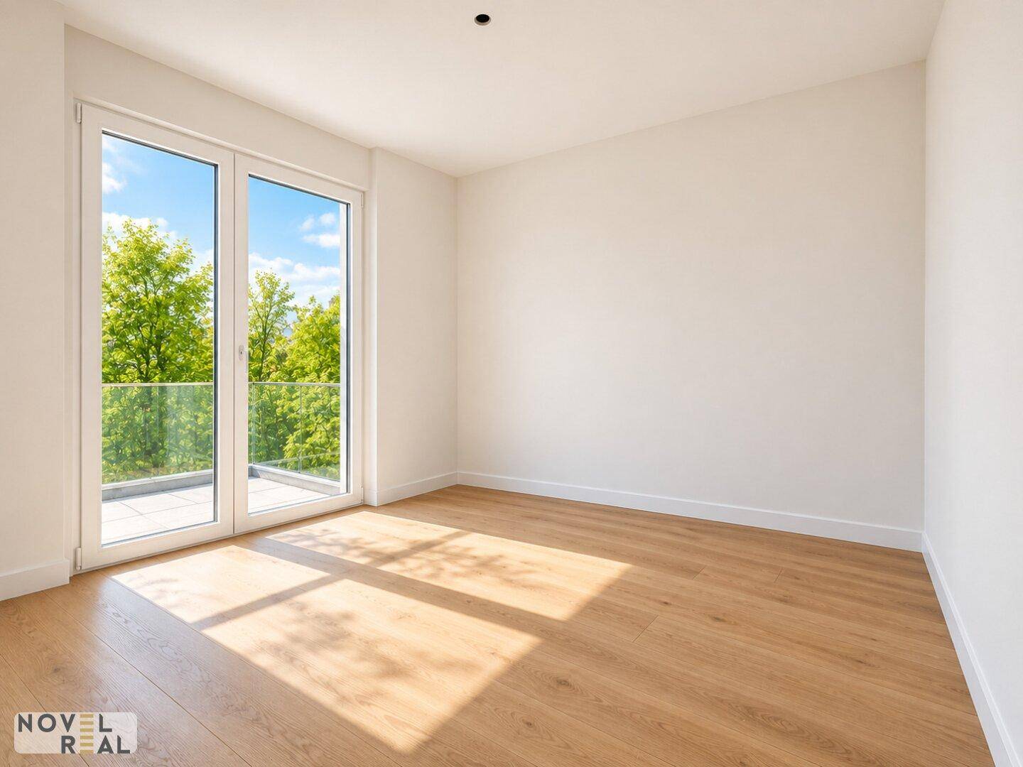 Sonniger Raum mit Holzboden und Zugang zu einem Balkon oder einer Terrasse.