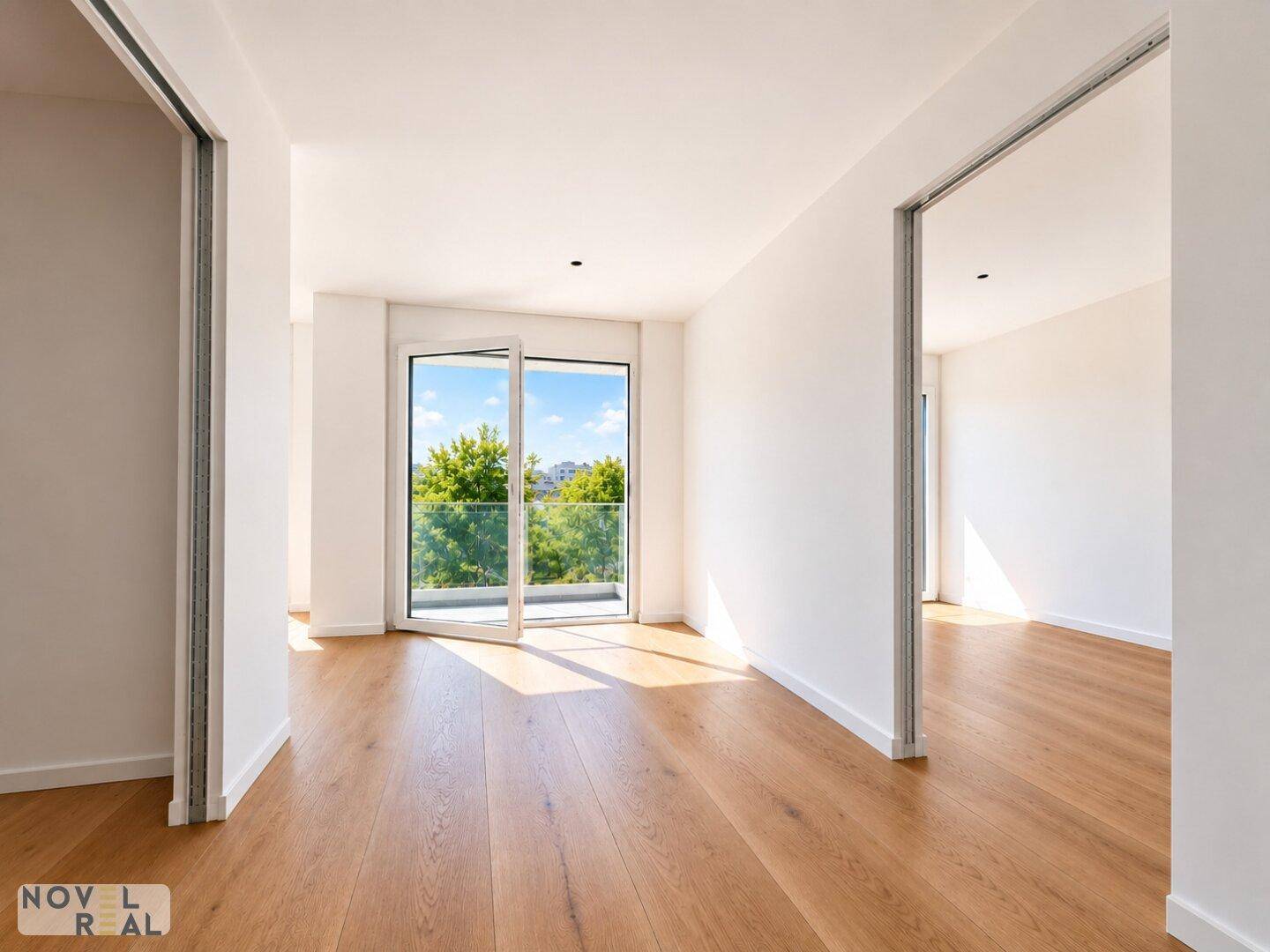 Heller Flur mit Holzboden und einem Fenster, das den Blick ins Grüne freigibt.
