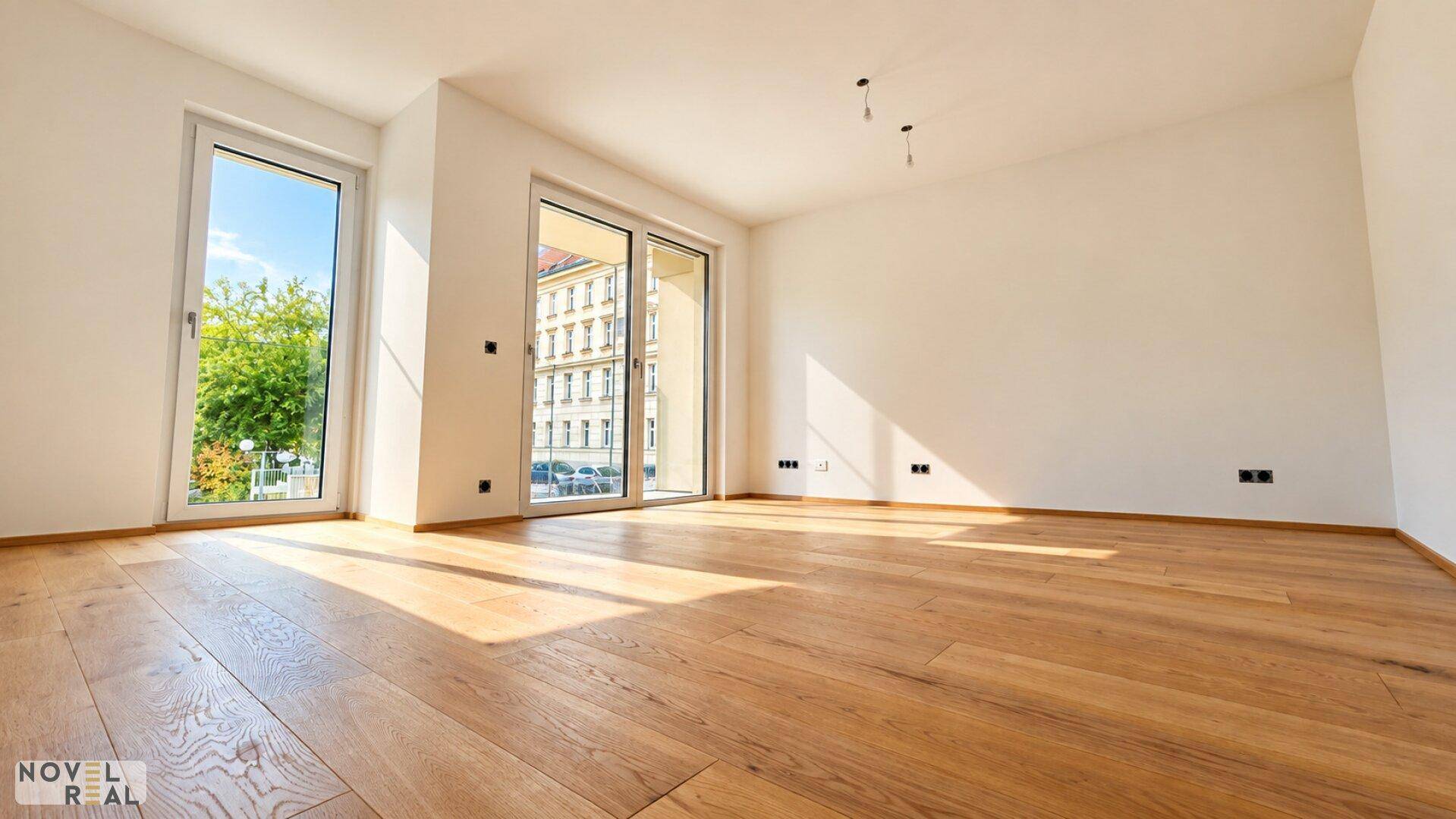 Lichtdurchfluteter Wohnraum mit Eichenparkett und Zugang zu einem Balkon.