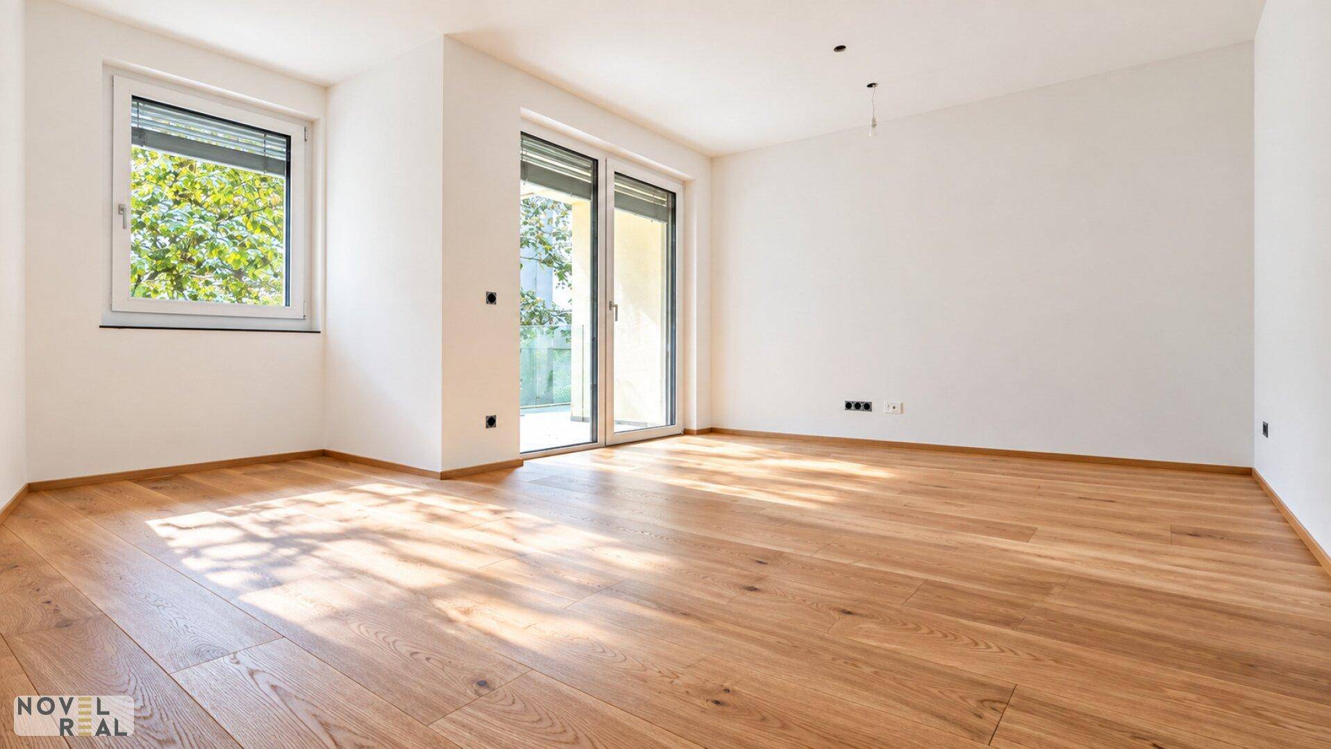 Lichtdurchfluteter Raum mit Holzboden und einer großen Schiebetür, die ins Freie führt.