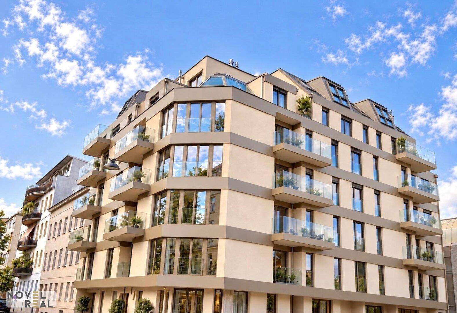 Modernes Wohngebäude mit gestaffelten Balkonen und großen Fensterflächen.