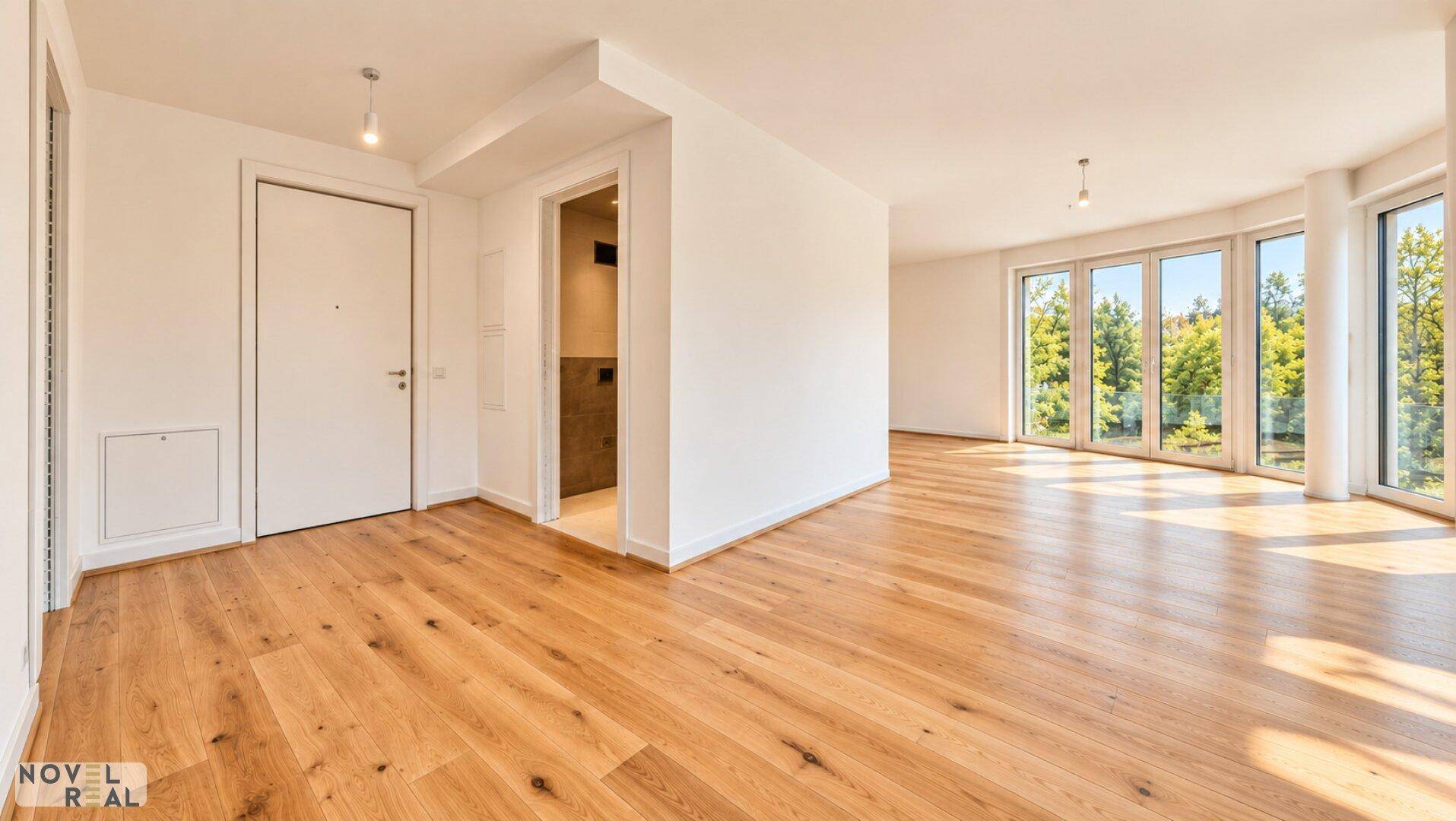 Heller Wohnbereich mit Holzboden und Zugang zu einem weiteren Raum sowie großen Fenstern.