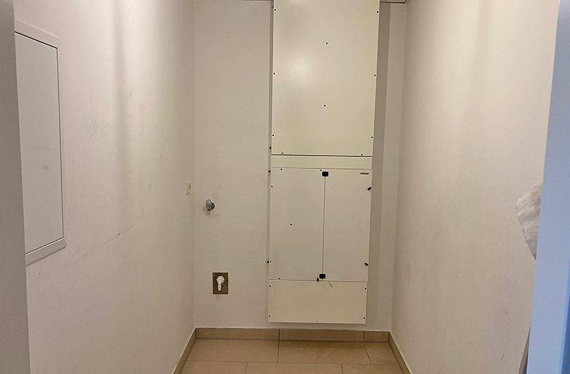 Praktischer Abstellraum mit Fliesenboden und Installationsschacht, ideal für Haushaltsgeräte oder Lagerung.