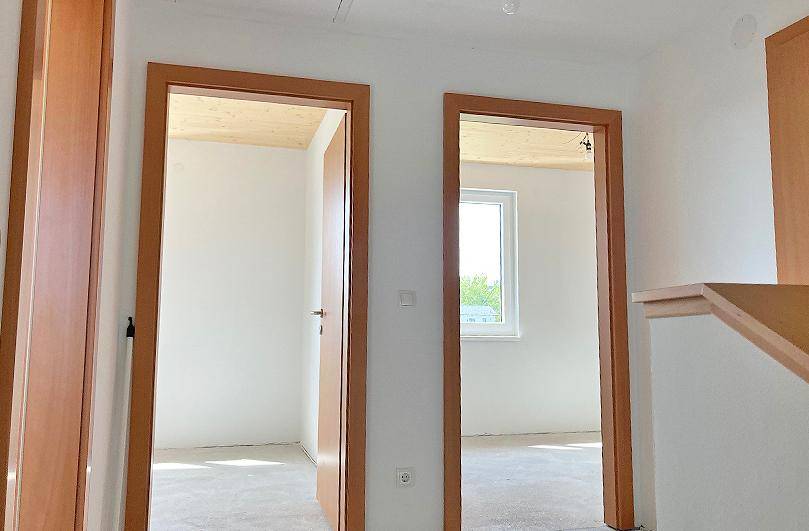 Heller Flur mit Holzbalkendecke und Zugang zu weiteren Räumen im Obergeschoss.