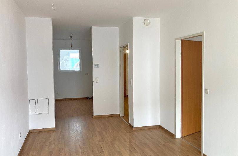 Geräumiger Flur mit Laminatboden und Türen zu angrenzenden Zimmern in einer modernen Wohnung.