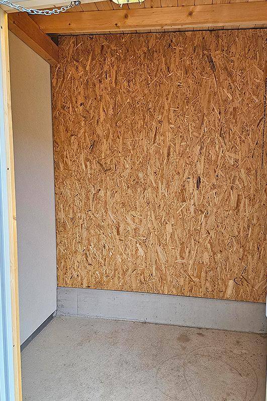 Praktischer Abstellraum mit OSB-Platten an den Wänden und Betonboden.
