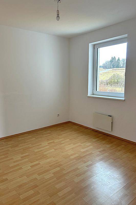 Helles Zimmer mit Laminatboden und weitem Blick ins Grüne.