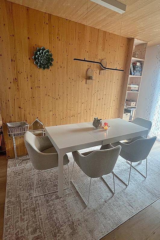 Moderner Essbereich mit Holzwänden, großem Esstisch und stilvollen Stühlen.