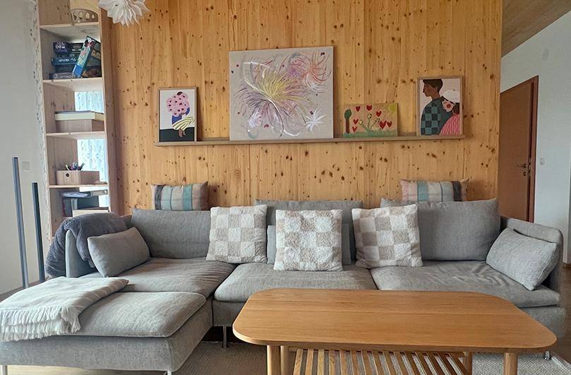 Gemütliches Wohnzimmer mit Holzwänden, großem Ecksofa und moderner Dekoration.