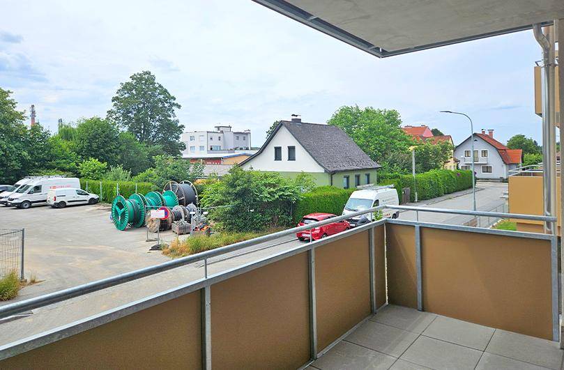 Balkon mit Blick auf eine Straße, umliegende Gebäude und einen industriellen Lagerbereich.