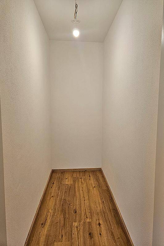 Kleiner, leerer Abstellraum mit Laminatboden und weißen Wänden, ideal für zusätzlichen Stauraum.