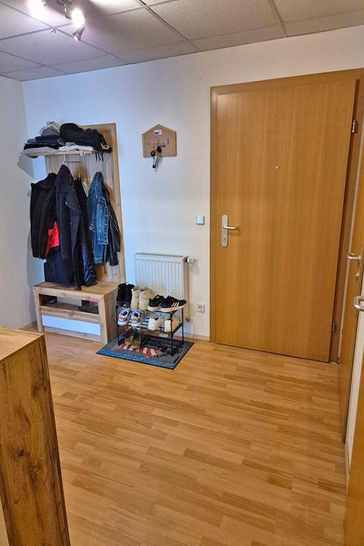 Eingangsbereich mit Garderobe, Schuhregal und Laminatboden.