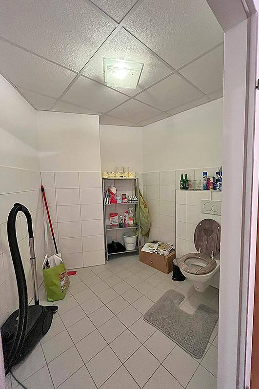 Einfaches WC mit Fliesenboden und Stauraum, auch als Abstellraum genutzt.