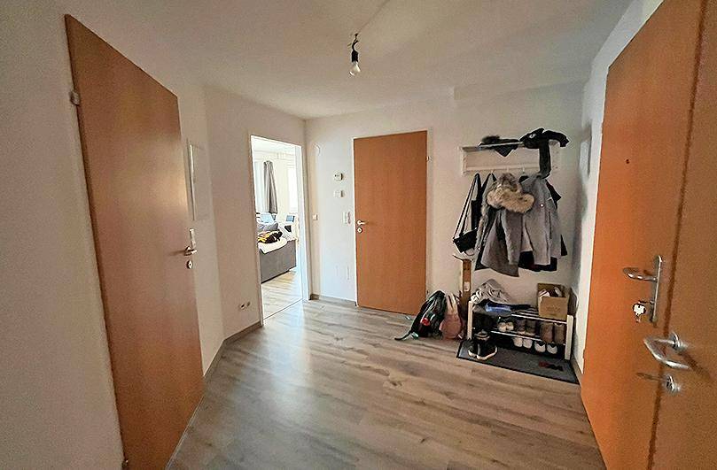 Geräumiger Flur mit Laminatboden und Garderobe, der zu den verschiedenen Wohnbereichen führt.