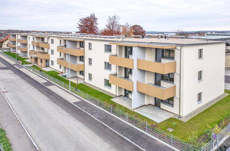 Luftaufnahme des modernen Wohnkomplexes mit Balkonen, Terrassen und Grünflächen in einer Wohnsiedlung.