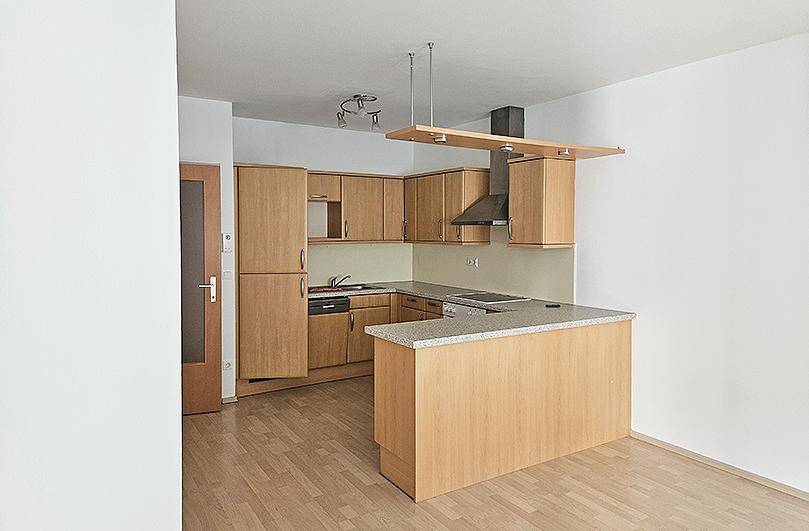 Voll ausgestattete Einbauküche mit hellen Holzfronten, Geräten und einer praktischen Theke.